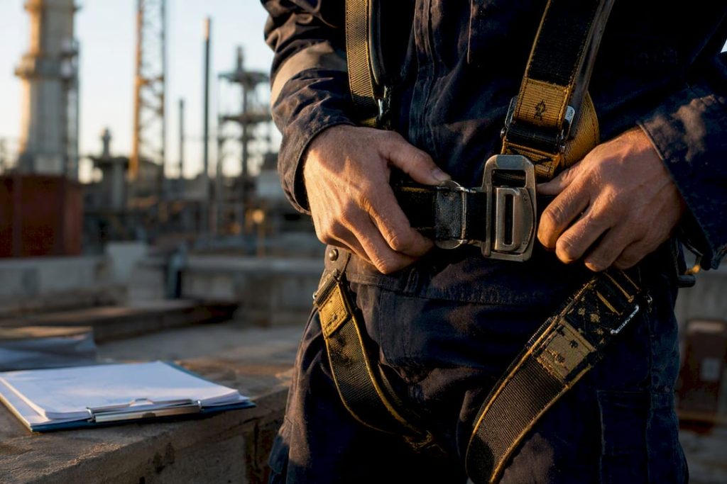 Technician fastening safety harness buckle