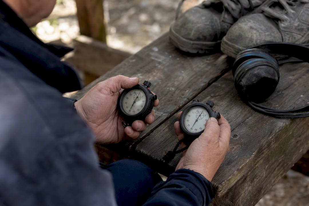 Hands comparing timers at industrial site