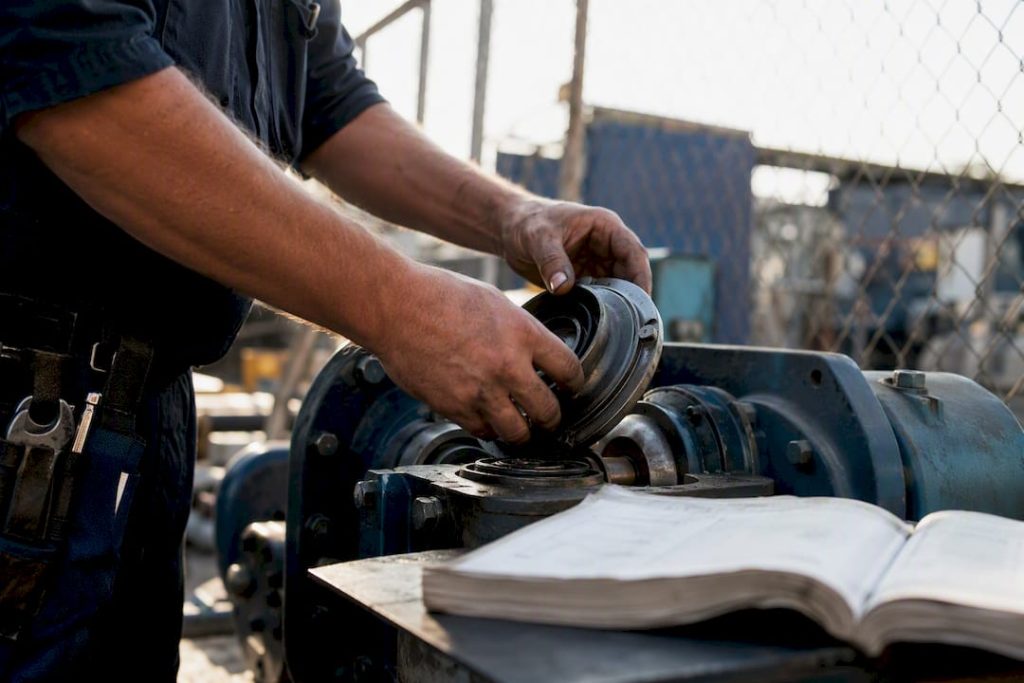 Technician hands inspecting pump component