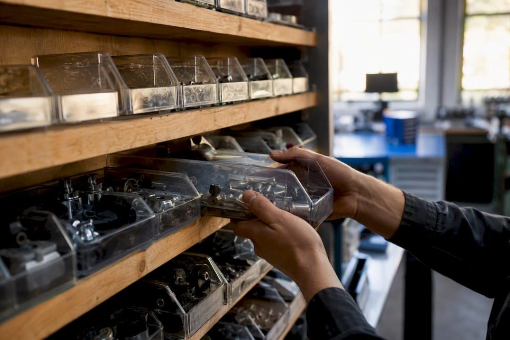 Hands organizing spare parts bins